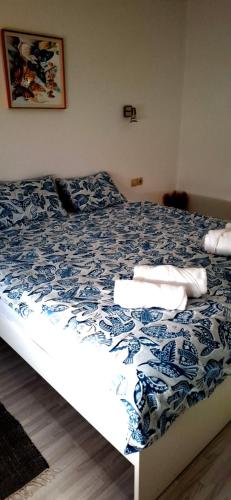 a bedroom with a bed with a blue and white comforter at LaLuna House in Cernik