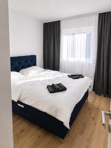 a bedroom with a bed with a blue headboard and a window at Central Аpartment Foca with garage in Foča