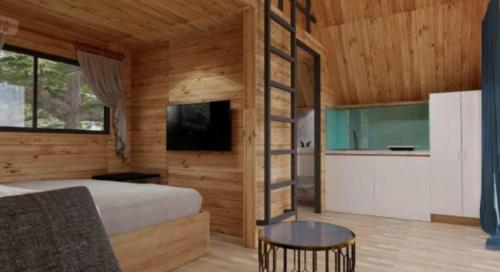 a bedroom with a bed and a tv and a table at Vang Vieng KT Resort in Vang Vieng