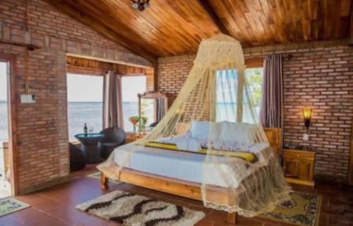 a bedroom with a bed with a mosquito net at Vang Vieng KT Resort in Vang Vieng