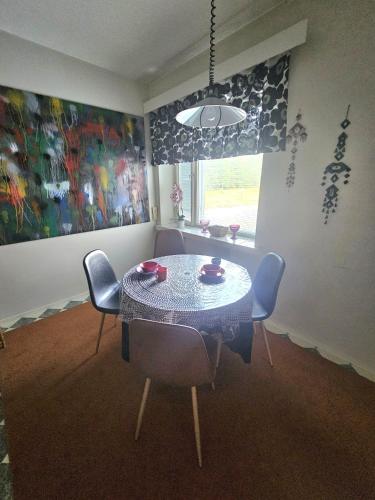 a dining room with a table and chairs and a window at Rönnypiha 