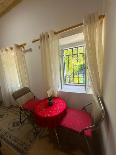 a table and two chairs in a room with a window at Bujtina Tata in Curraj