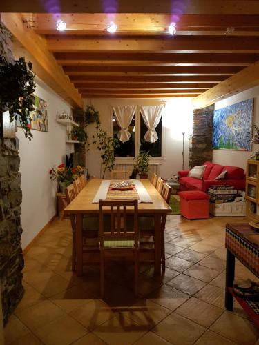 a living room with a table and a red couch at B&B La Cà De La Frà in Gravedona