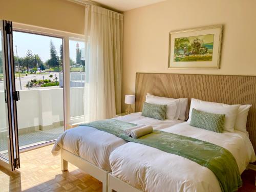 a bedroom with a large bed with a large window at Loewenhoff Seaview Suite 2 in Swakopmund
