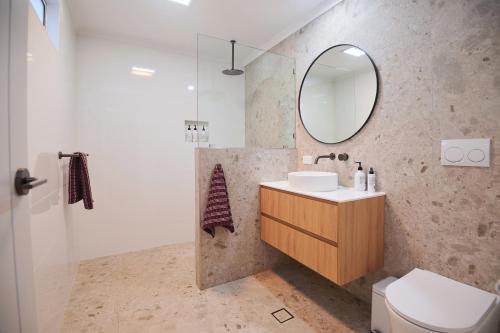 a bathroom with a sink and a mirror at The Merredin Treasury Cottage in Merredin