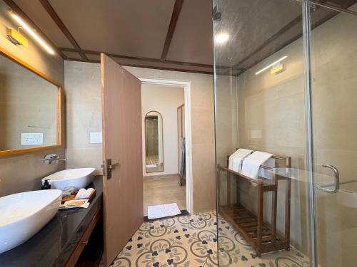 a bathroom with a sink and a glass shower at RajVana, Ranthambore in Khilchipur