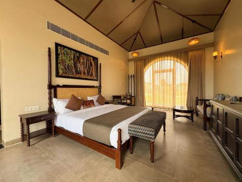 a bedroom with a large bed and a sink at RajVana, Ranthambore in Khilchipur