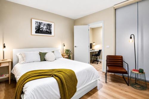a bedroom with a bed and a chair and a desk at Elevated CBD Retreat - Views & Pool & Sauna! in Melbourne