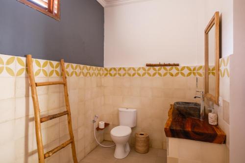 a bathroom with a toilet and a sink at Amed Sudi House in Amed