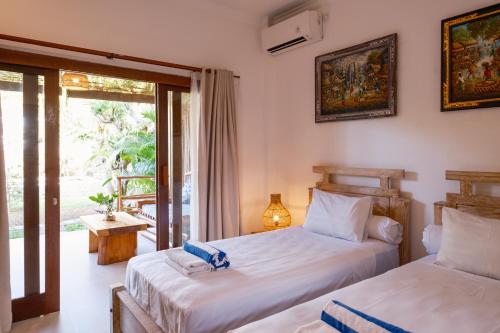 two beds in a room with a balcony at Amed Sudi House in Amed