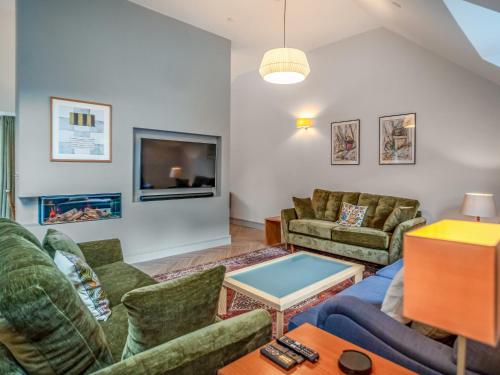 a living room with couches and a flat screen tv at Pandy Newydd in Trefriw