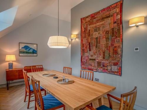 a dining room with a wooden table and chairs at Pandy Newydd in Trefriw