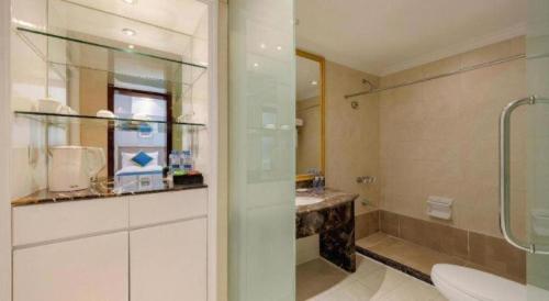 a bathroom with a shower and a toilet and a sink at Datong Hotel in Datong