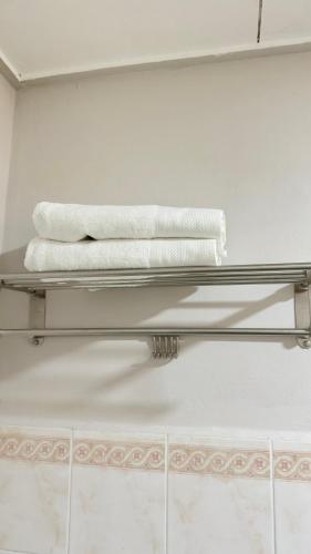two towels on a glass shelf in a bathroom at Damai Laut Serene Stay Studio Lumut in Lumut
