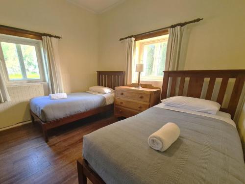 a bedroom with two beds and two windows at Bungaree Station in Clare