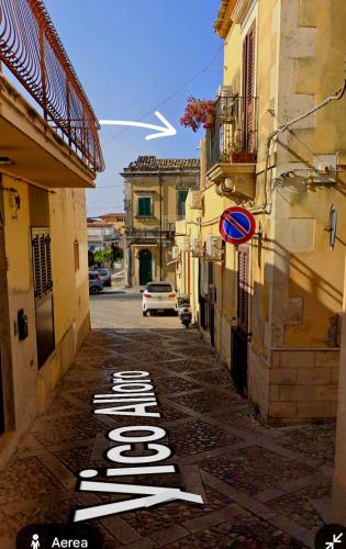 a street with a sign on the side of a building at La Perla Di Noto in Noto