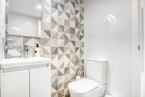 a white bathroom with a toilet and a sink at Bonaire in Gandía