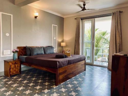 a bedroom with a large bed and a large window at The Baga Pescador in Baga