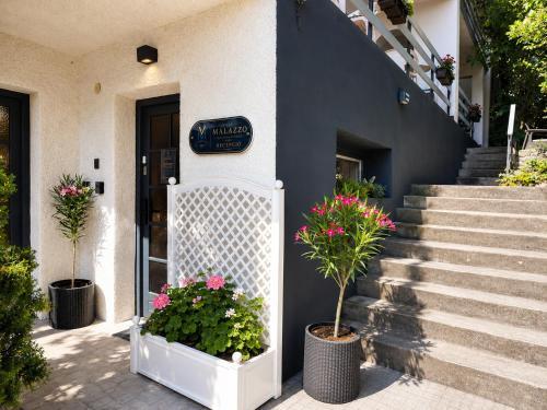 a building with two potted plants in front of it at Villa Malazzo in Balatongyörök