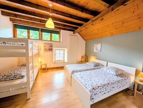 two beds in a room with wooden ceilings at Le Chalet Cozy & Spa in Wildersbach