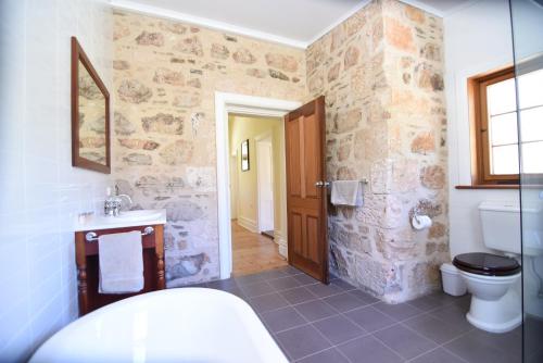 a stone bathroom with a toilet and a sink at Bungaree Station in Clare