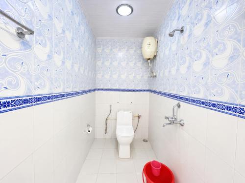 a bathroom with a toilet and blue and white tiles at Hotel Pinecrest Inn Darjeeling With Mountain View Room And Parking - Restaurant Facility in Darjeeling