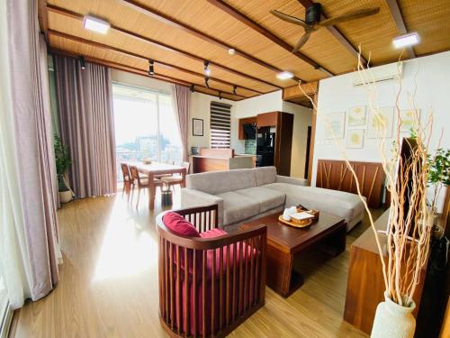 a living room with a couch and a table at XÔI Sakamoto 2 Suites Kim Ma in Hanoi