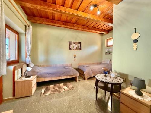 a bedroom with two beds and a table at Lavanda Vendégház in Németkér