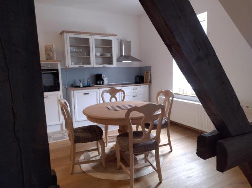 a kitchen with a table and chairs in a room at Etzauer Mühle im Taunus, Suite in Weilrod