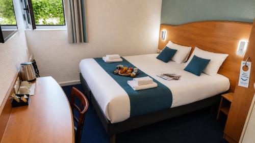 a hotel room with a bed with two teddy bears on it at BRIT HOTEL Caen Hérouville in Hérouville-Saint-Clair