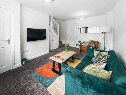 a living room with a green couch and a table at Ashby Meadows in Spilsby