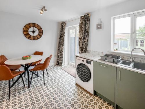 a kitchen with a table and a sink and a table at Ashby Meadows in Spilsby