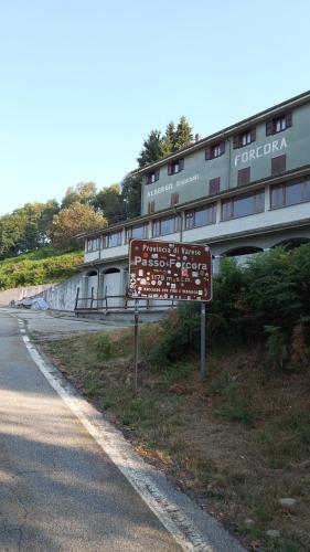 a sign on the side of a road next to a building at Foresteria del Passo Forcora in Maccagno Superiore