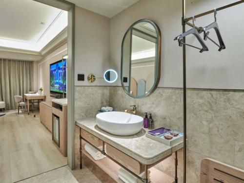 a bathroom with a sink and a mirror at Mercure Lanzhou West in Lanzhou