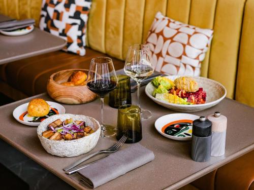 a table with plates of food and glasses of wine at Pullman Lyon in Lyon