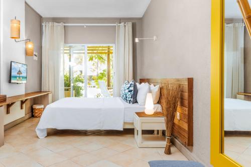 a bedroom with a large white bed and a window at Friday Attitude in Trou d'Eau Douce