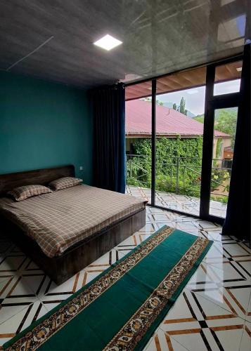 a bedroom with a bed and a green wall at Горный уют in Burchmulla