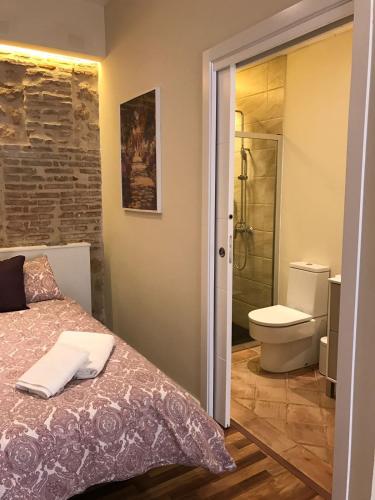 a bedroom with a bed and a bathroom with a toilet at La Quinta Hacienda in Córdoba