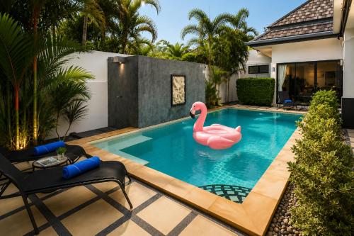 a swimming pool with a pink swan in the middle at Pool Villa Clos Vougeot Tropical Vibe in Ban Saiyuan (1)