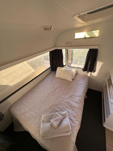 a small bed in the back of a camper van at Henarata Homestead in Wakefield