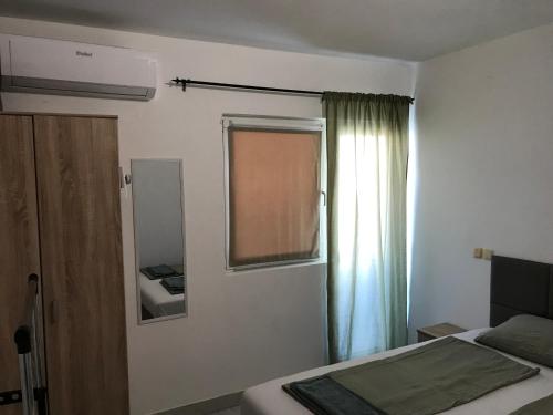 a small bedroom with a bed and a window at Apartments Gumla 1 in Stara Novalja