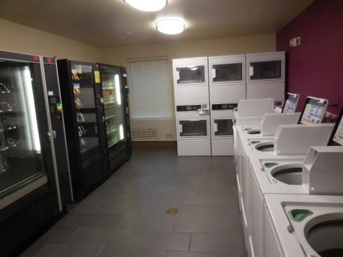 a kitchen with white appliances and white counters at Aptel Studio Hotel in Anchorage