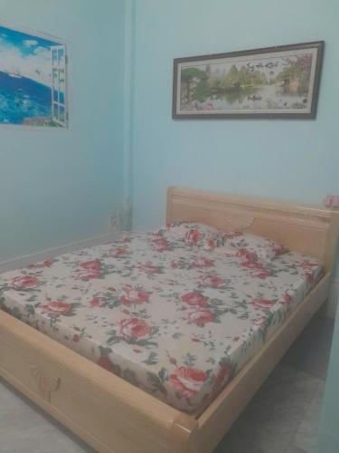 a bed in a bedroom with a floral bedsheet at An Loc Motel in Vĩnh Long