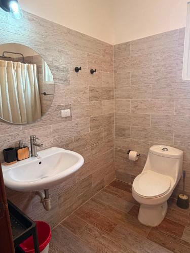 a bathroom with a toilet and a sink and a mirror at Vittoria House Garden in Bayahibe