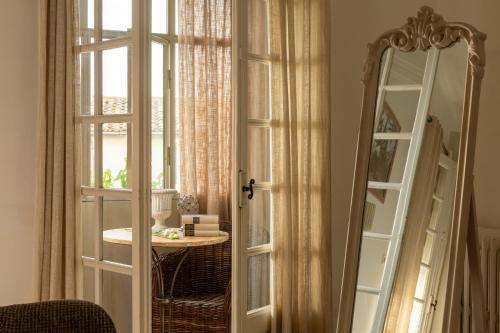a room with a window and a mirror and a table at La Regalido in Fontvieille