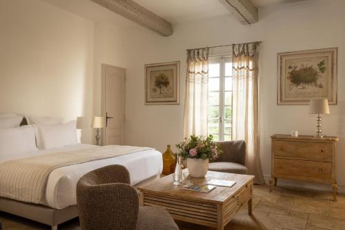 a hotel room with a bed and a table with flowers at La Regalido in Fontvieille