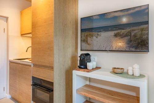 a kitchen with a table and a tv on the wall at BALI BLIZZ - App 15 in Benz