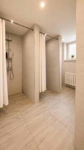 a bathroom with a shower and a tile floor at Pokoje Bielsko in Bielsko-Biała