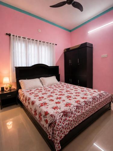 a bedroom with a large bed with pink walls at Rose Villa Kovalam in Kovalam
