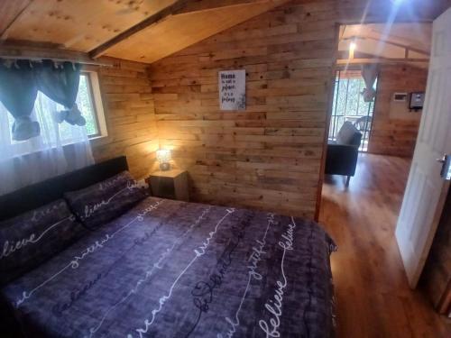 a bedroom with a bed in a log cabin at Diamond Vault Rustic Mountain Cabins in Hogsback